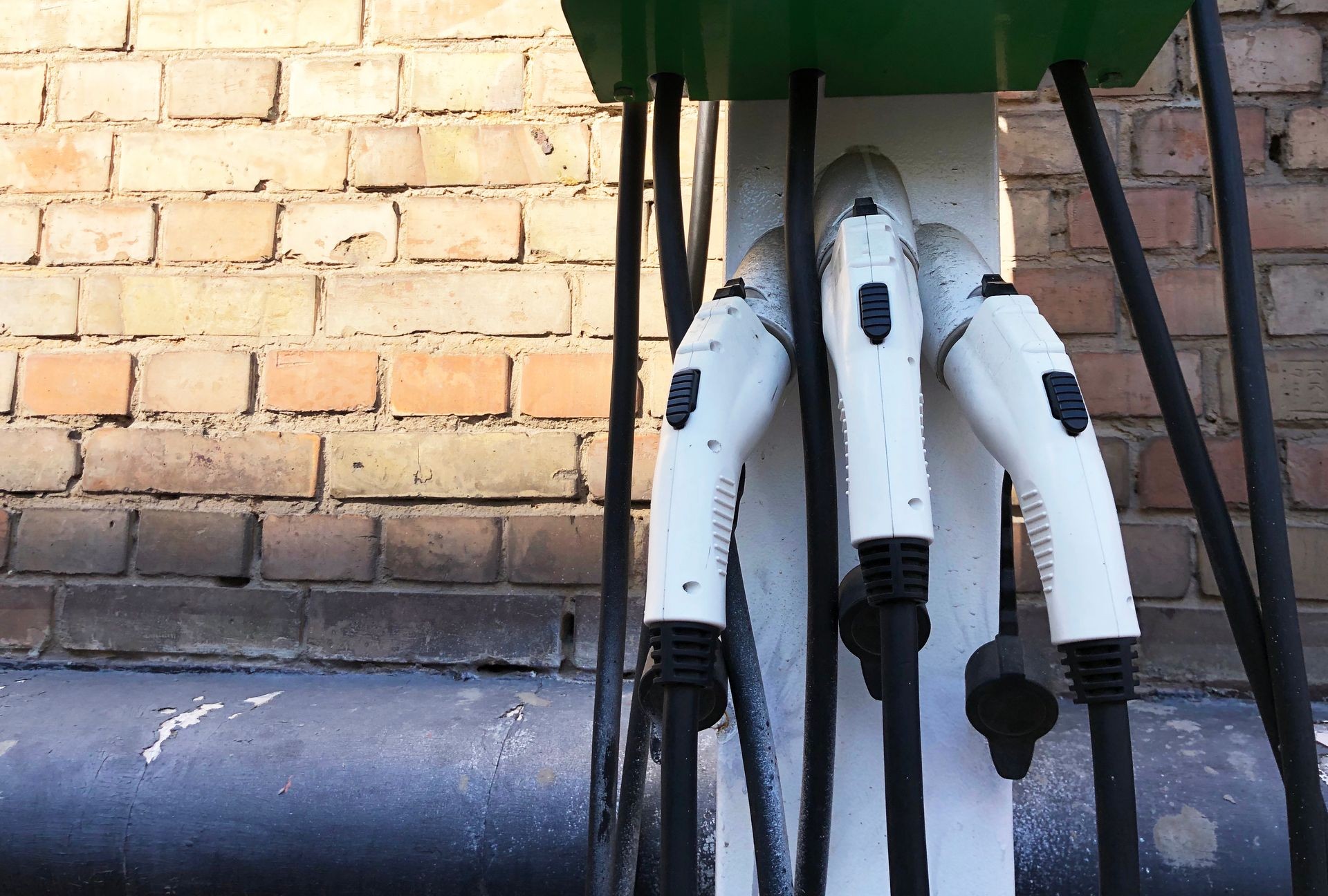 Three power supplies connected to electric vehicle charging station. power cable supply plugged in the electric vehicle charging (Ev) station
